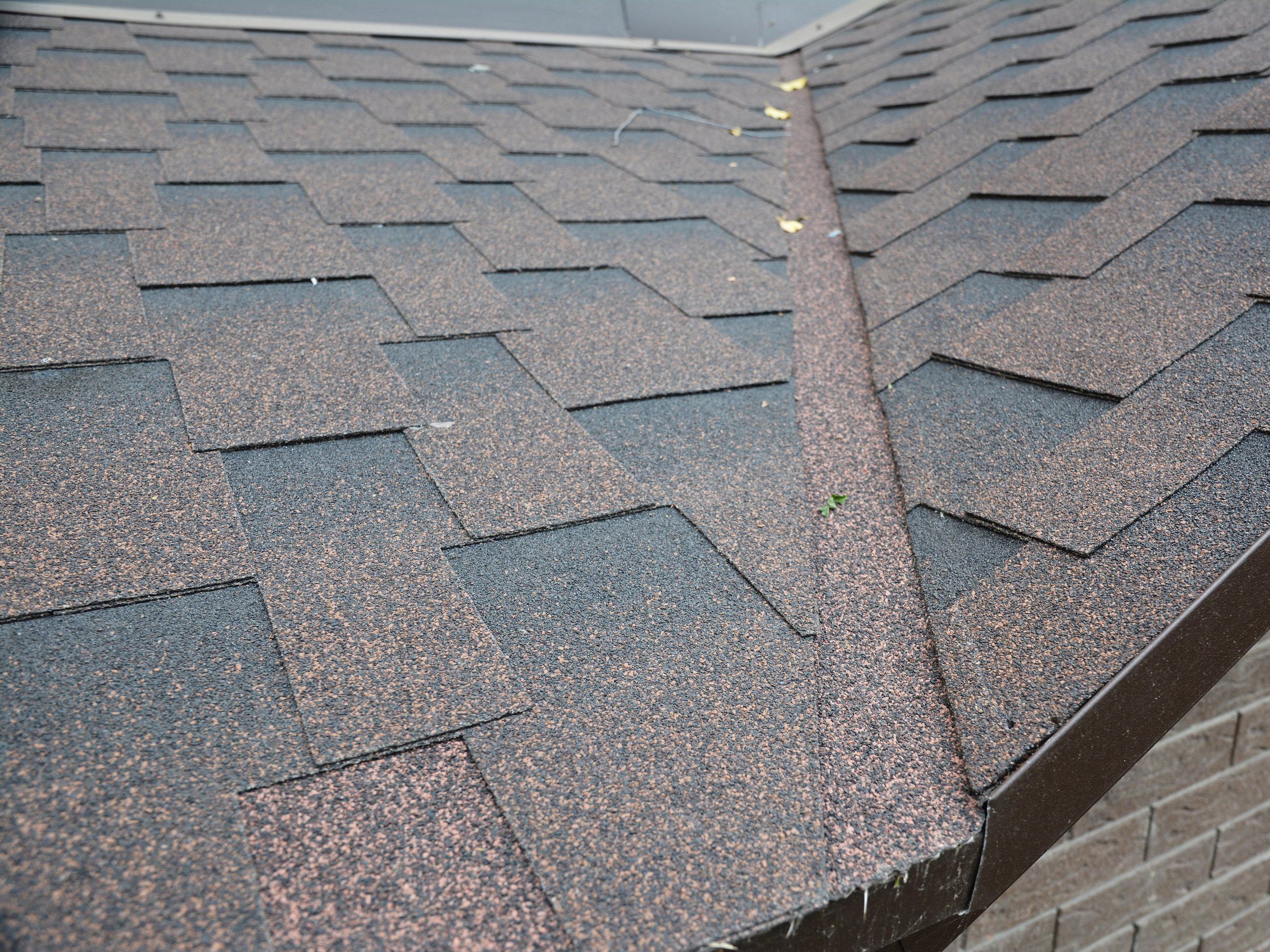 A shingle valley and drip edge on a brown architectural-shingle roof.