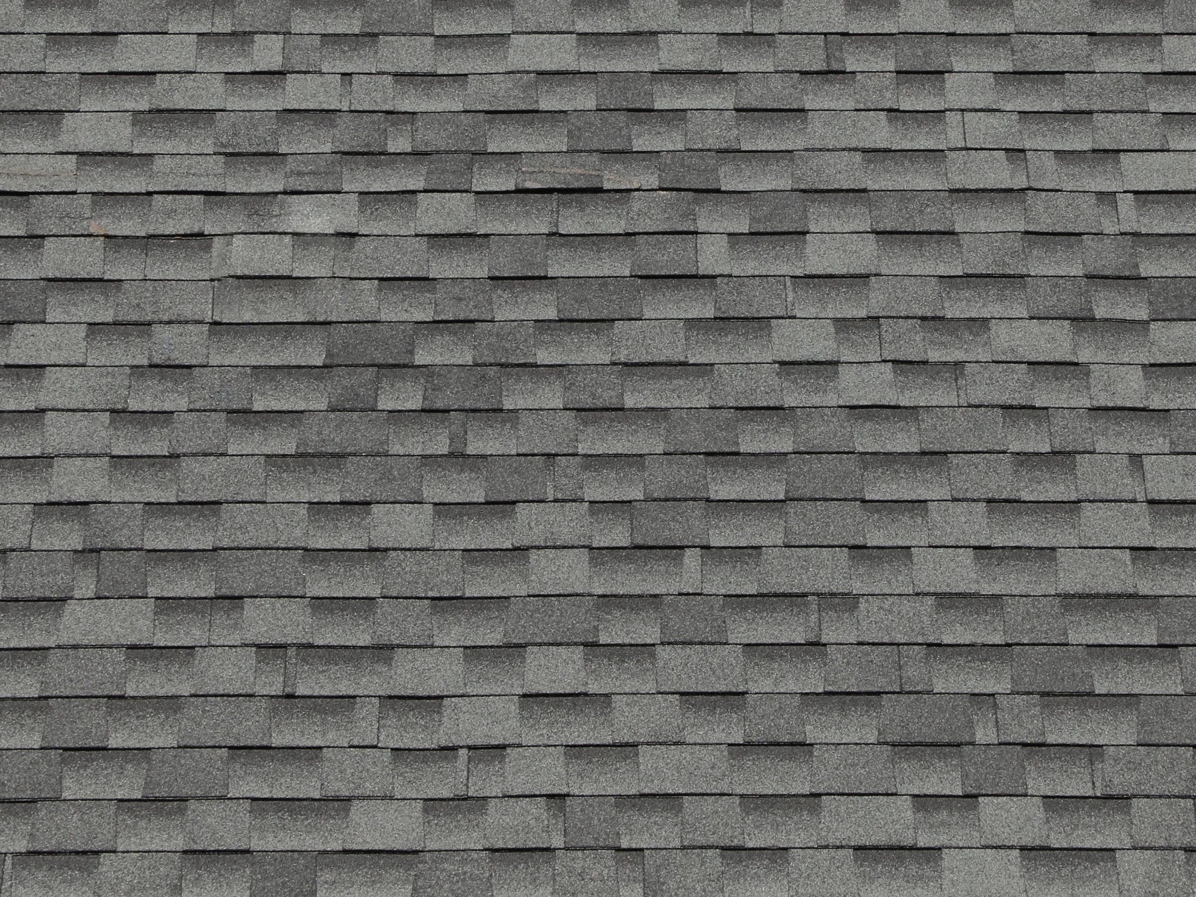 A field of grey architectural shingles, close up.