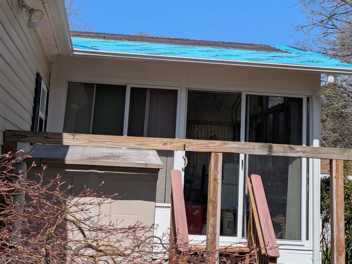 Tear-off in progress, the roof decking exposed and underlayment going down.
