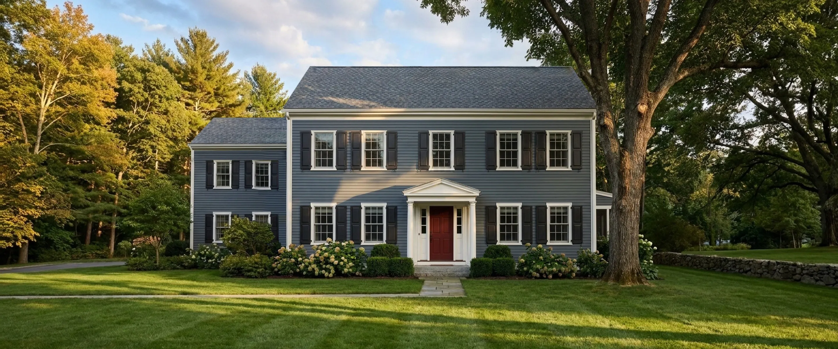 A grey-blue clapboard colonial home with a new charcoal-grey architectural shingle roof